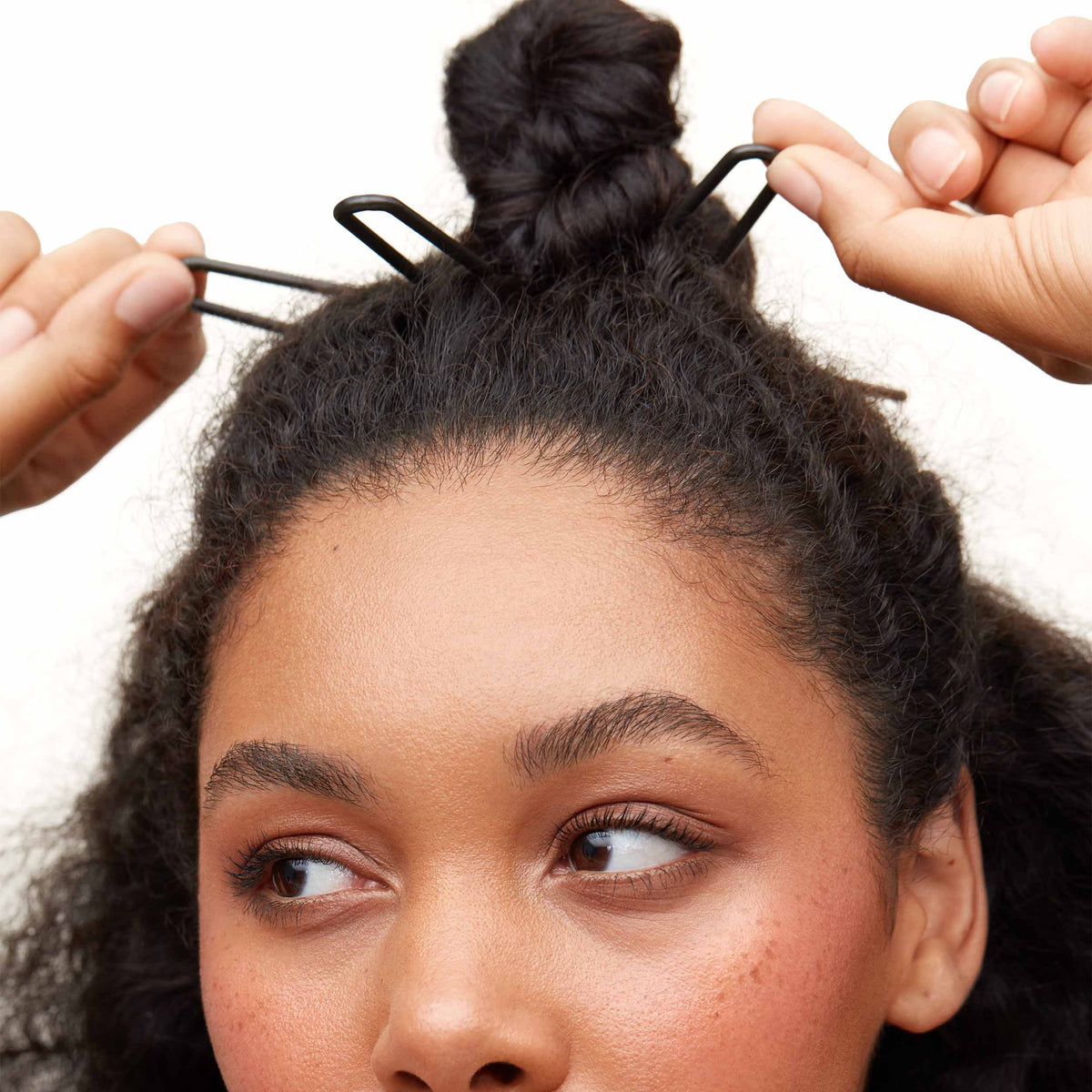 Pinning a top knot with two Day Rate Beauty pins